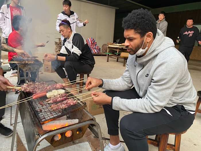 Freeman manning the grill, making connections, with Shenzhen teammates.